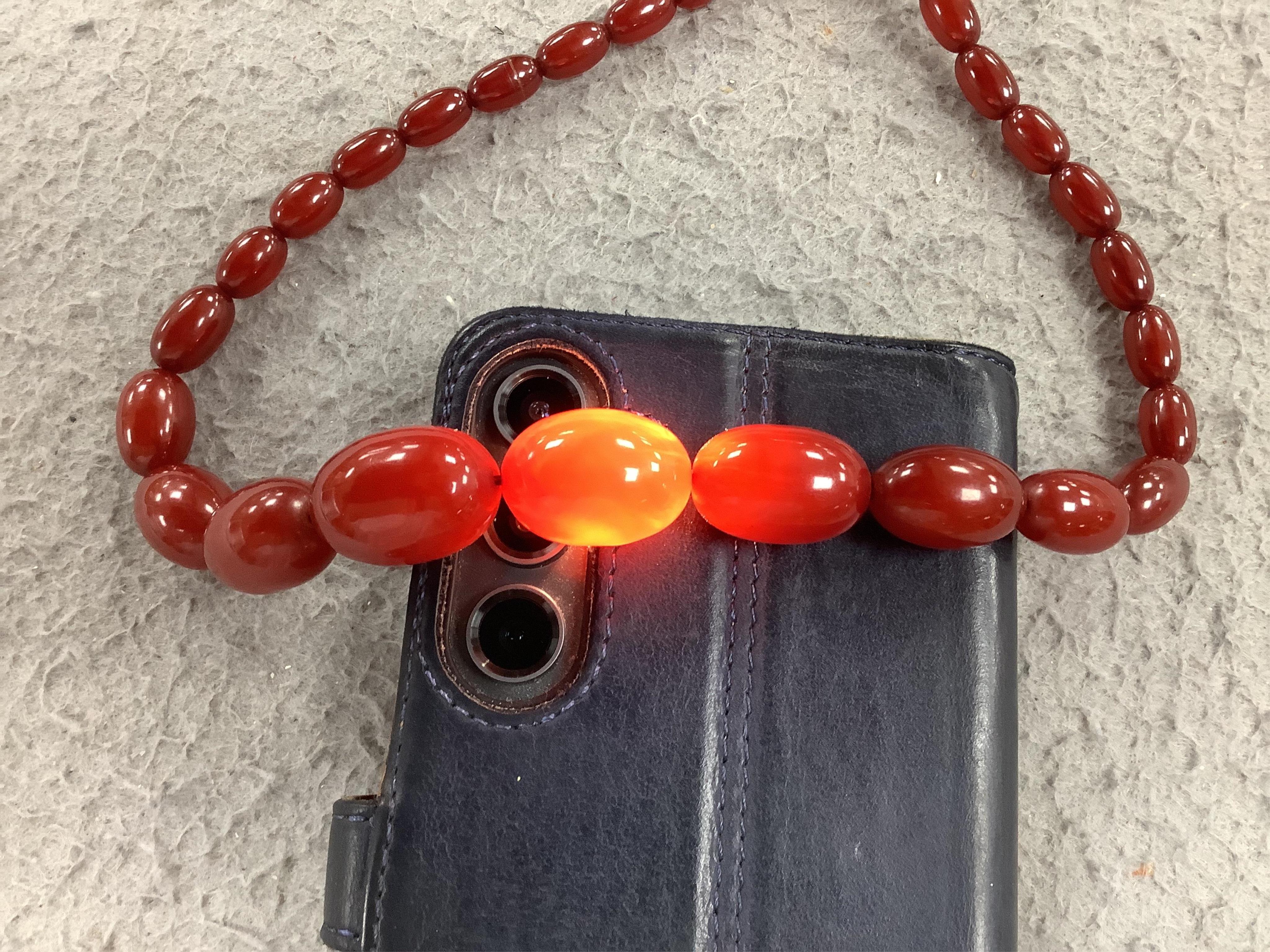 A single strand graduated simulated cherry amber bead necklace, 68cm, gross weight 52 grams. Condition - fair to good